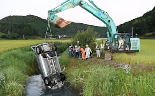 転落した川から引き揚げられる乗用車（18日午前、高知県四万十町）=共同