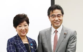 握手する小池都知事(左)と若狭衆院議員。（16日、東京都中央区）