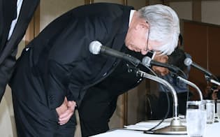 記者会見で頭を下げる神戸製鋼所の川崎博也会長兼社長（手前、10月13日、東京都港区）
