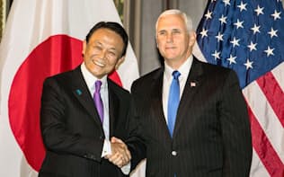 日米経済対話で握手する麻生財務相（左）とペンス米副大統領（16日、ワシントン）=代表撮影・共同