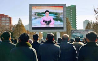 29日、北朝鮮の平壌駅前で、新型のICBM「火星15」の発射実験を伝える「重大報道」を見守る市民ら=共同