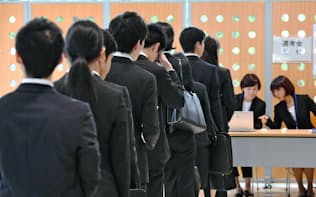 採用面接の受付に並ぶ就活生（6月、東京都内）