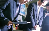 記者会見で頭を下げる日本カヌー連盟の古谷専務理事（左）ら=9日午後、東京都渋谷区
