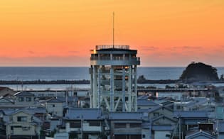 朝焼けに染まる静かな港町に高さ22メートルの津波避難タワーがそびえる（高知県黒潮町）=淡嶋健人撮影