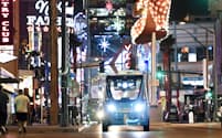ネオンに彩られたラスベガスの街を巡回するドライバーのいない自動運転バス。観光客などを乗せ約1キロの公道を静かに走る（17日）=井上昭義撮影