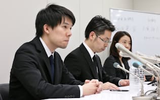 記者会見するコインチェックの和田晃一良社長（左）ら（26日夜、東証）