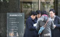 コインチェックが入るビルを訪れた利用客や報道陣ら（27日午前、東京都渋谷区）