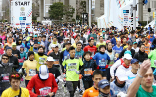 東京マラソンで都庁前をスタートするランナー(25日、東京・西新宿)=共同 東京マラソンで都庁前をスタートするランナー(25日、東京・西新宿)=共同