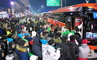 平昌冬季五輪の開会式を終え、帰りのバスを待つ人たち(9日、韓国・平昌)=共同 平昌冬季五輪の開会式を終え、帰りのバスを待つ人たち(9日、韓国・平昌)=共同