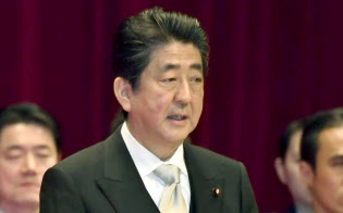 防衛大学校の卒業式で訓示する安倍首相。左端は小野寺防衛相(18日午前、神奈川県横須賀市)=共同 防衛大学校の卒業式で訓示する安倍首相。左端は小野寺防衛相(18日午前、神奈川県横須賀市)=共同