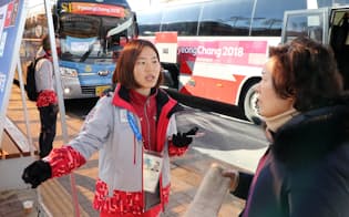 2月初旬、平昌五輪会場近くで観光客を案内するボランティア(左)。五輪もパラリンピックも善意で支えられてこそ成立する