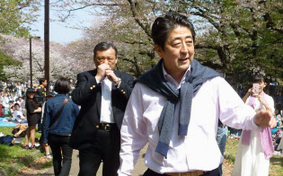 セーターを肩に掛けて散歩する安倍首相(1日午後、東京都渋谷区の代々木公園)=共同 セーターを肩に掛けて散歩する安倍首相(1日午後、東京都渋谷区の代々木公園)=共同