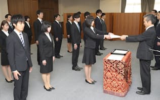 矢野康治官房長(右)から辞令を受け取る財務省の新入職員（2日午前、財務省）=代表撮影
