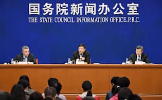 北京で4日記者会見する中国の王受文商務次官（右）と朱光耀財政次官（中央）=共同