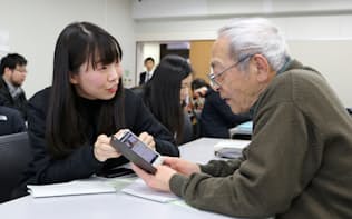 災害時のスマホ活用法を高齢者に教える学生（1月、熊本市中央区の熊本学園大）