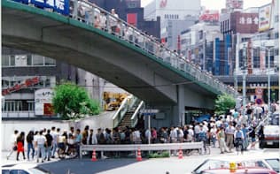91年の日本ダービー当日、水道橋陸橋からウインズ後楽園に向かう人の列=JRA提供