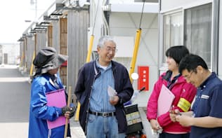 仮設団地で看護師らの訪問を受ける一人暮らしのお年寄り（左から2人目）=熊本県益城町