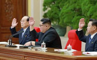 20日、平壌で開かれた朝鮮労働党の中央委員会総会で挙手する金正恩党委員長（中央）=コリアメディア提供・共同