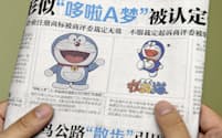 　2日、中国紙に掲載された「ドラえもん」（左）と福建省のスポーツ用品企業が商標登録していたキャラクター（共同）