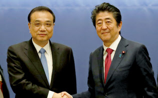 日中知事省長フォーラムで握手する中国の李克強首相(左)と安倍首相(11日午前、札幌市内のホテル)=共同 日中知事省長フォーラムで握手する中国の李克強首相(左)と安倍首相(11日午前、札幌市内のホテル)=共同