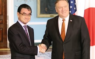 ポンペオ米国務長官（右）と握手する河野外相（23日、ワシントン）=共同