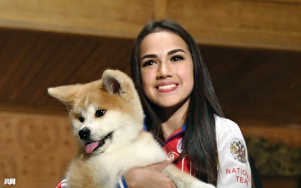  贈呈された秋田犬の子犬を抱くアリーナ・ザギトワ選手(26日、モスクワ)=共同