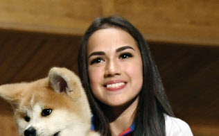 贈呈された秋田犬の子犬を抱くアリーナ・ザギトワ選手(26日、モスクワ)=共同 贈呈された秋田犬の子犬を抱くアリーナ・ザギトワ選手(26日、モスクワ)=共同