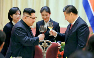 北朝鮮の労働新聞が9日掲載した、中国遼寧省大連で乾杯する金正恩朝鮮労働党委員長(左)と習近平国家主席の写真=コリアメディア提供・共同 北朝鮮の労働新聞が9日掲載した、中国遼寧省大連で乾杯する金正恩朝鮮労働党委員長(左)と習近平国家主席の写真=コリアメディア提供・共同