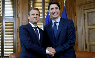 マクロン仏大統領(左)と会談したカナダのトルドー首相(6日)=ロイター マクロン仏大統領(左)と会談したカナダのトルドー首相(6日)=ロイター