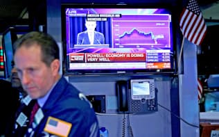 13日、ニューヨーク証券取引所でFRBの利上げを伝えるテレビ映像=ロイター
