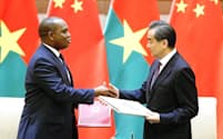 中国は5月、ブルキナファソと国交を結んだ（北京の釣魚台迎賓館で行われた署名式で握手するブルキナファソのバリー外相（左）と中国の王毅国務委員兼外相）=共同