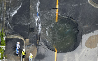 地震で水道管が破裂した現場(18日午前、大阪府高槻市)=共同 地震で水道管が破裂した現場(18日午前、大阪府高槻市)=共同