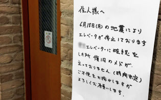地震で停止したエレベーターの復旧の見通しが立たないことを知らせる張り紙(19日、大阪府吹田市、画像の一部を加工しています)=共同 地震で停止したエレベーターの復旧の見通しが立たないことを知らせる張り紙(19日、大阪府吹田市、画像の一部を加工しています)=共同