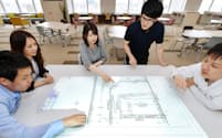 図面を見ながら住宅設備の設計について意見を交わすエプコの社員（東京都墨田区）