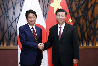 2017年11月、ベトナム・ダナンでの日中首脳会談で安倍晋三首相(左)と握手を交わす習近平国家主席=新華社・AP 2017年11月、ベトナム・ダナンでの日中首脳会談で安倍晋三首相(左)と握手を交わす習近平国家主席=新華社・AP