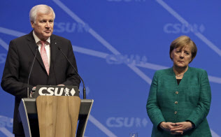 ドイツのゼーホーファー内相(左)とメルケル首相=AP ドイツのゼーホーファー内相(左)とメルケル首相=AP