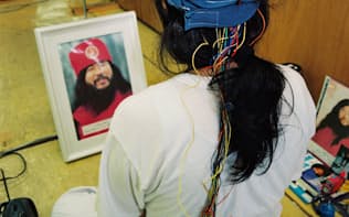 オウム真理教「富士山総本部」の道場で修業をする信者。教祖と同じ脳波を流すとされる「PSI」と呼ばれるヘッドギアをつけていた（1995年7月、静岡県富士宮市）