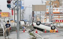 愛媛県大洲市の豪雨で路上に横転したままの車両（8日午前9時42分）=共同