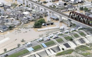 建物が水没、浸水した岡山県倉敷市真備町地区で始まった排水作業（8日午後2時46分）=共同