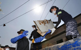 強い日差しの下、片付けを手伝うボランティアら(15日午前9時13分、岡山県倉敷市真備町地区)=共同 強い日差しの下、片付けを手伝うボランティアら(15日午前9時13分、岡山県倉敷市真備町地区)=共同