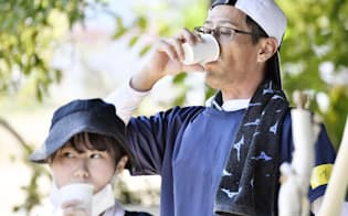 作業の合間、水分を補給するボランティアの男性ら（15日、広島県熊野町）=共同