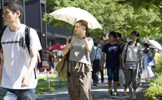 強い日差しの中、日傘を差して歩く女性(15日午後、名古屋市)=共同 強い日差しの中、日傘を差して歩く女性(15日午後、名古屋市)=共同
