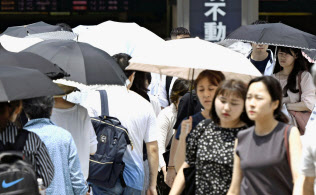 厳しい暑さの中、日傘を差して歩く女性ら(19日午後、東京・JR新宿駅前)=共同 厳しい暑さの中、日傘を差して歩く女性ら(19日午後、東京・JR新宿駅前)=共同
