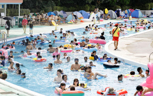 大勢の人でにぎわう東京都練馬区の遊園地「としまえん」のプール(21日午後)=共同 大勢の人でにぎわう東京都練馬区の遊園地「としまえん」のプール(21日午後)=共同