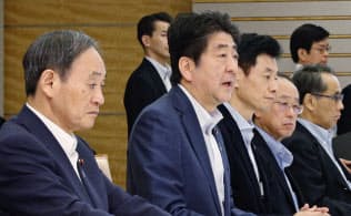 西日本豪雨の対策本部会議で発言する安倍首相。左は菅官房長官（７月29日午後、首相官邸）＝共同