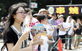 最高気温が39.9度を記録した名古屋市内で、うちわを使って涼を求める人たち(5日)=共同 最高気温が39.9度を記録した名古屋市内で、うちわを使って涼を求める人たち(5日)=共同
