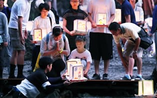 日航ジャンボ機墜落事故の犠牲者の冥福を祈り、灯籠を流す人たち（11日夜、群馬県上野村）