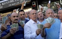 エルドアン大統領の呼びかけに応え、両替所にドルを持ち込むトルコ人ビジネスマン（14日、アンカラ）=ロイター