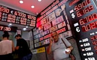 トルコの通貨リラの暴落はグローバル市場を揺さぶった（写真は8月17日、イスタンブールの両替所）=ロイター