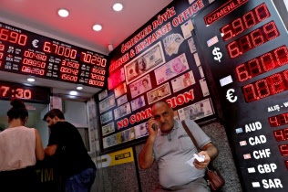 トルコの通貨リラの暴落はグローバル市場を揺さぶった(写真は8月17日、イスタンブールの両替所)=ロイター トルコの通貨リラの暴落はグローバル市場を揺さぶった(写真は8月17日、イスタンブールの両替所)=ロイター